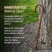 Handcrafted walking cane leaning against a tree with promotional text about its craftsmanship.