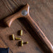 Wooden walking stick with 'U.S. Army Veteran' engraving on a wooden surface with bullets.