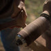 Close-up of a person holding a fishing reel with a blurred natural background