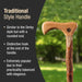 Wooden walking cane with rounded handle and hook, set against a blurred green outdoor background.
