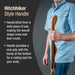 Person holding a wooden hiking stick with text describing its features on a dark background