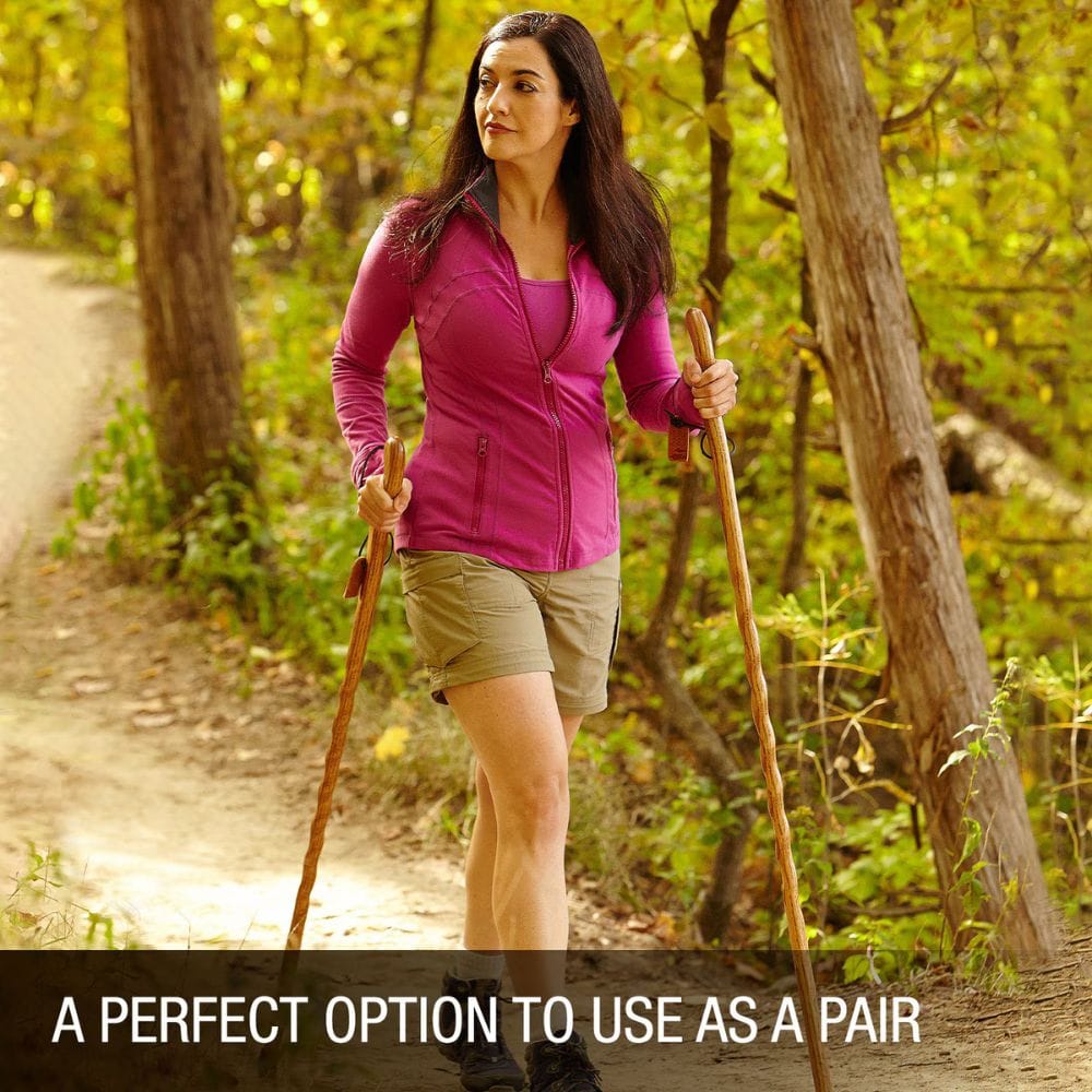 Woman hiking with walking sticks in a forest