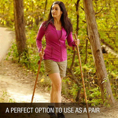 Woman hiking with walking sticks in a forest