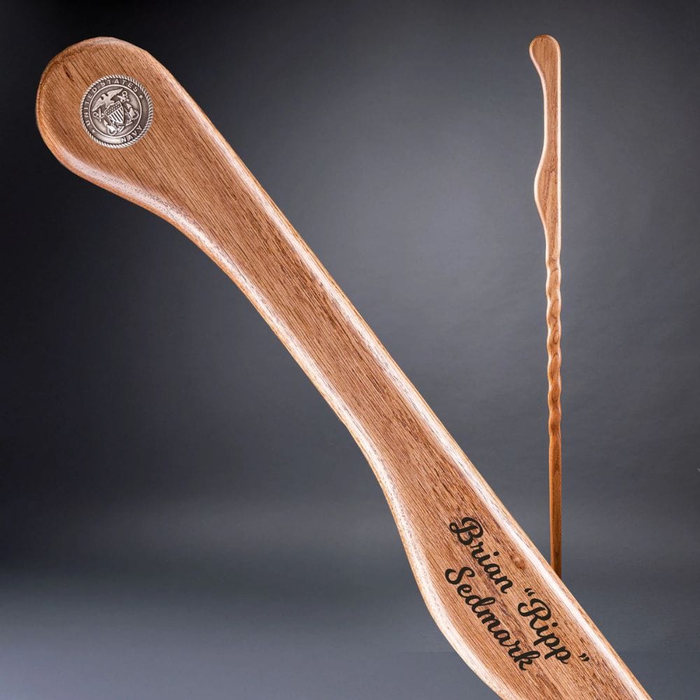 Wooden tool with engraved text on a gray background