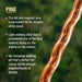 Wooden walking stick with text about pine walking sticks on a blurred green background
