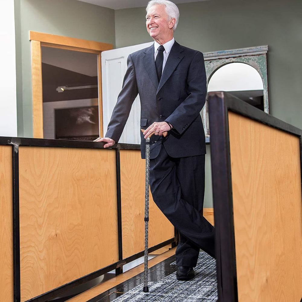 Man in a suit standing in an office setting with wooden partitions.