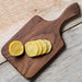 Sliced lemons on a wooden cutting board with a rustic wooden surface.