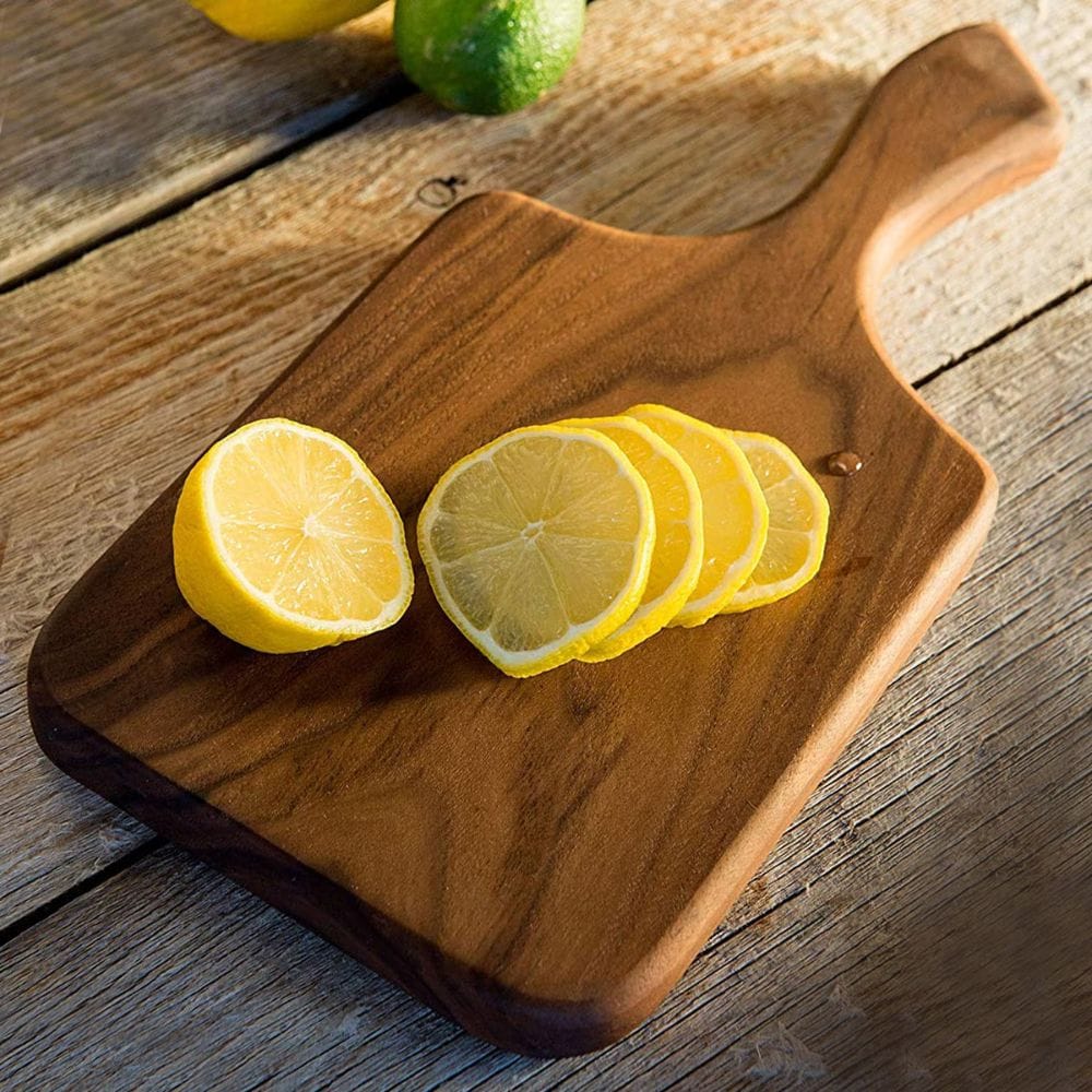 Wooden cutting board with sliced lemons on a wooden surface