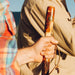 Hand holding a wooden walking stick with a blurred background