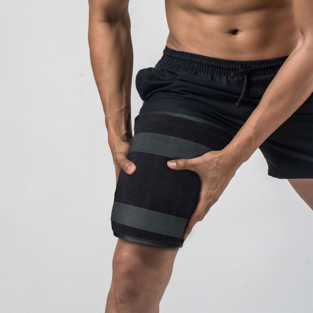 Person wearing black knee sleeves on a plain background