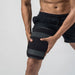 Person wearing black knee sleeves on a plain background
