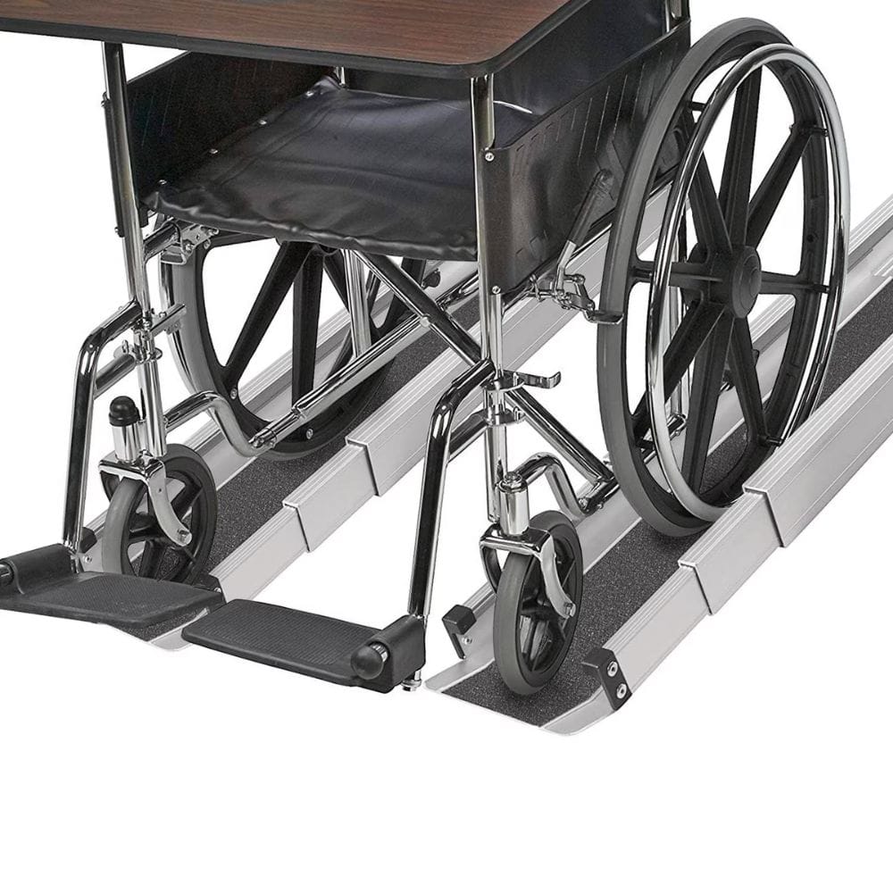 Wheelchair being used to ascend a set of stairs with a ramp attached.