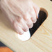 Hand pressing a button on a wooden surface