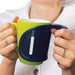 Person holding a green mug with a black handle