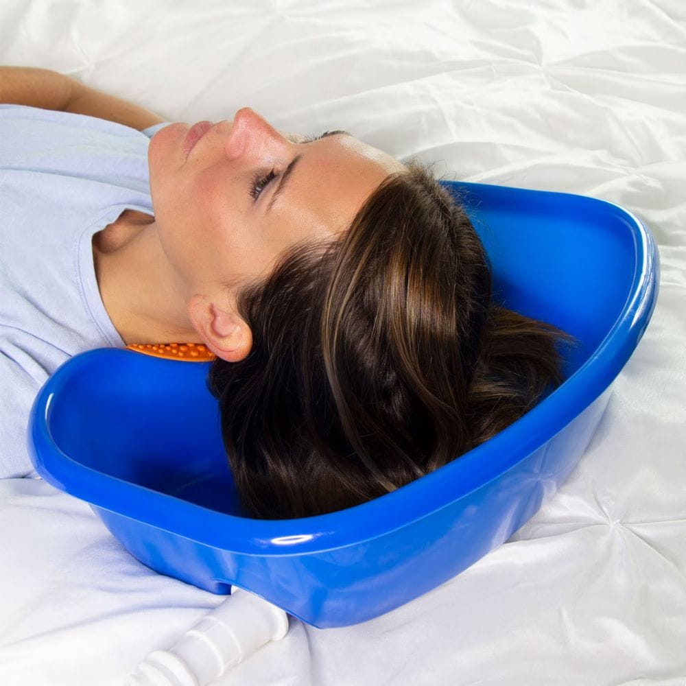 Woman lying on a white blanket with a blue basin over her head