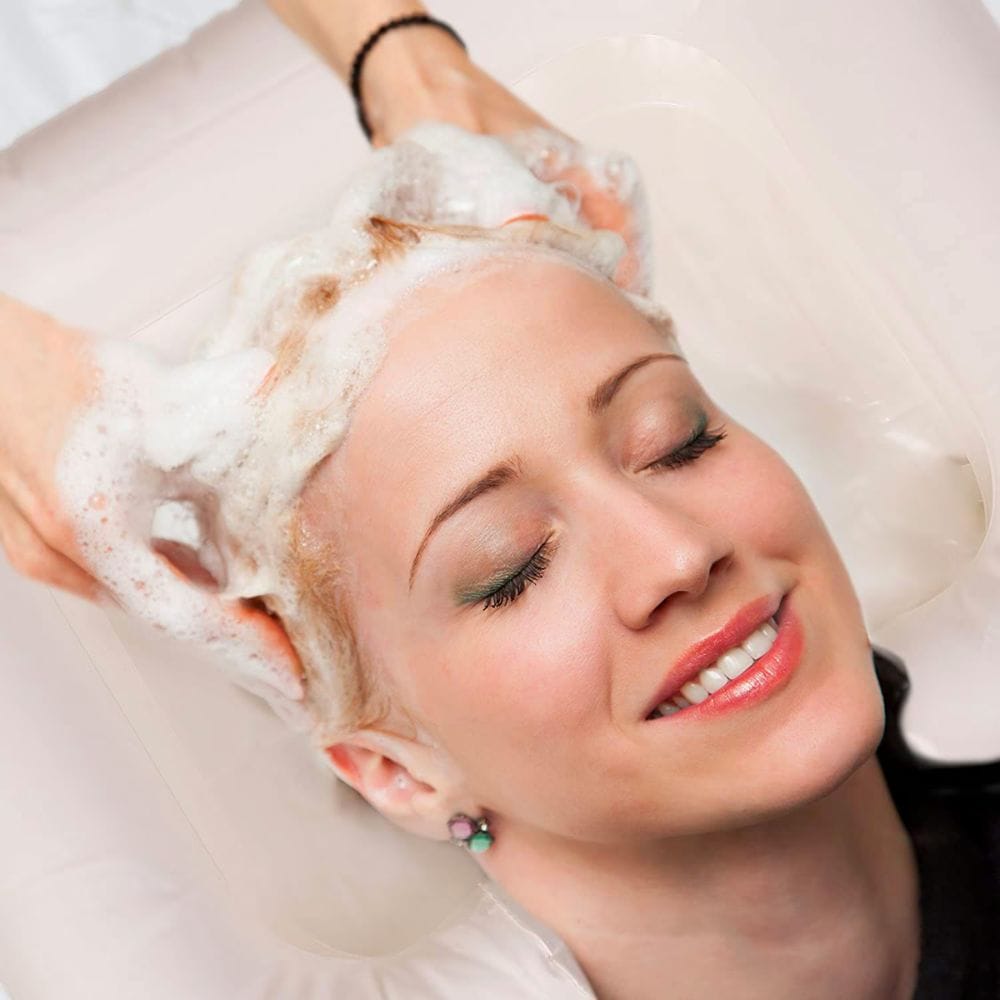 Woman receiving a scalp massage with a white towel on her head