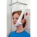 A woman wearing a white chin-lower support harness suspended from a metal frame, shown indoors against a white door and wall with measurement markings.