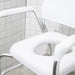White chair with metal frame against a tiled wall