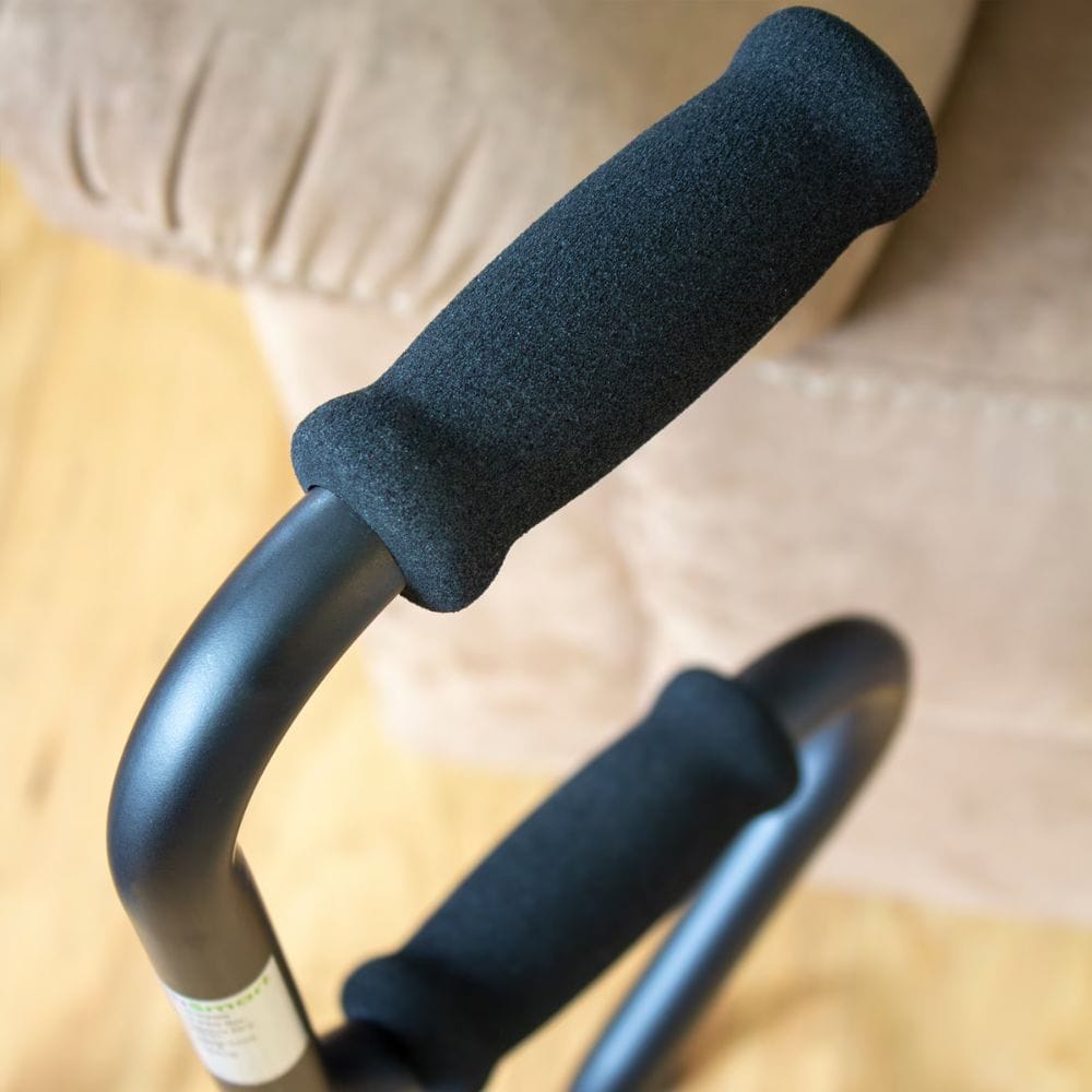 Close-up of black handles with foam grips on a beige background
