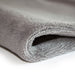 Close-up of a rolled-up gray towel on a white background