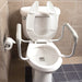 Toilet with a raised seat and grab bars installed in a bathroom.