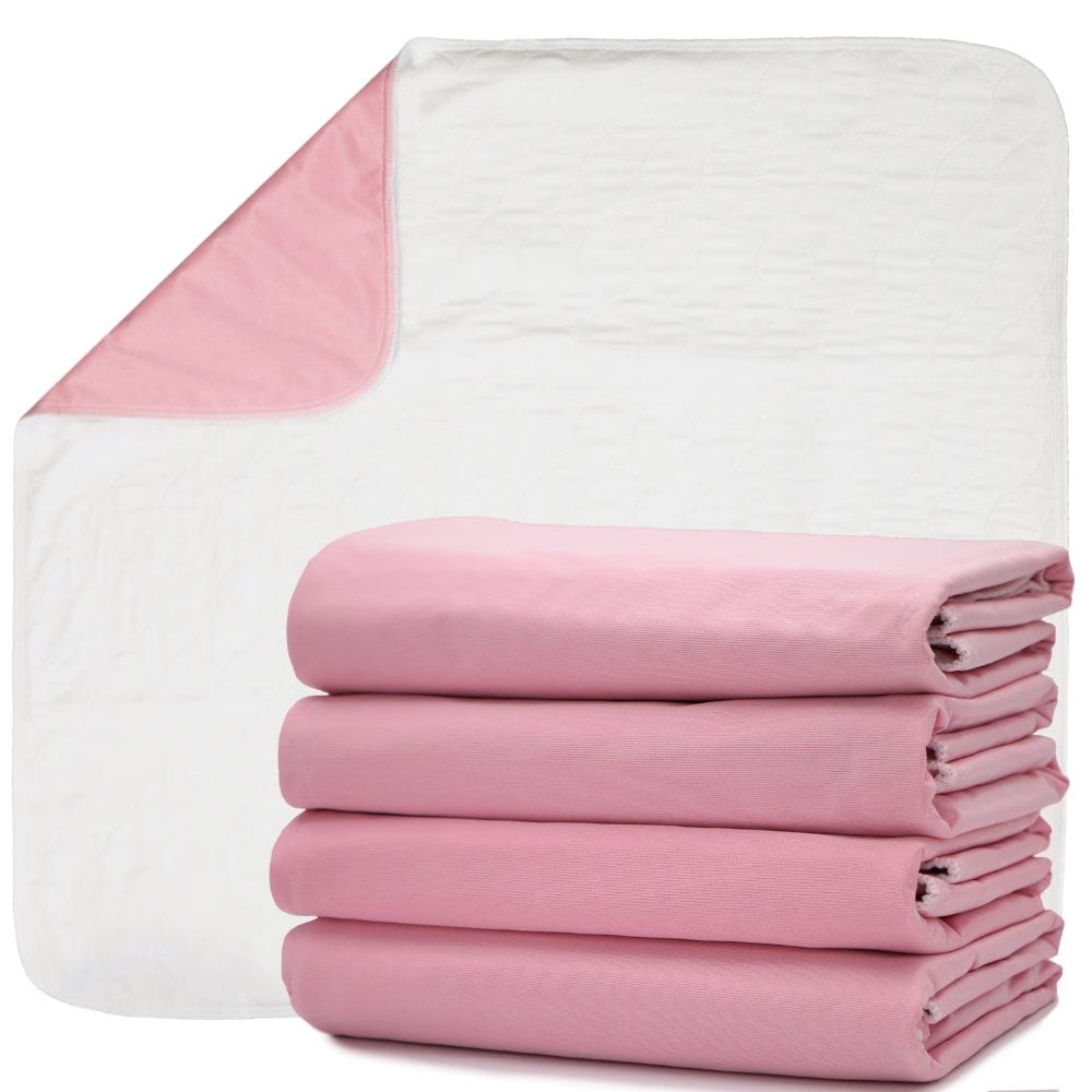 Pink and white baby changing pads shown on a clean white background, with one pad unfolded to display both sides and a stack of folded pink pads in front.