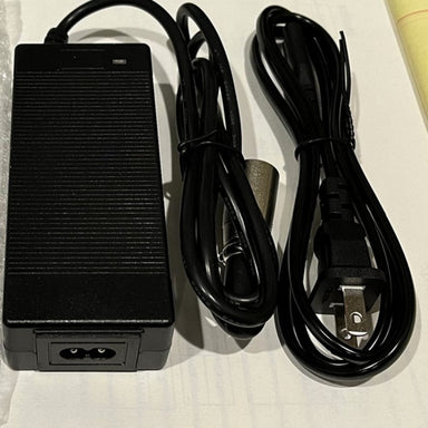 Black power adapter with cable on a light background