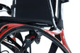 Close-up of the Monarch Mobility Ezi-Fold Carbon’s lightweight carbon fiber frame with orange accents beneath the seat.