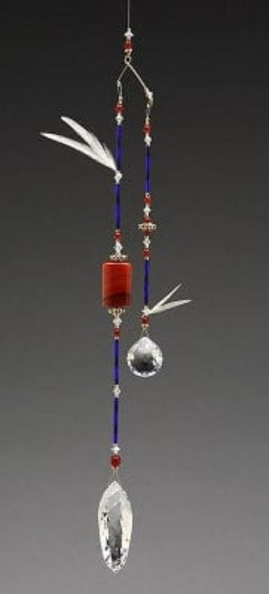 Decorative hanging ornament with beads and crystals on a gray background