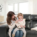 Woman holding a child on a couch in a bright living room