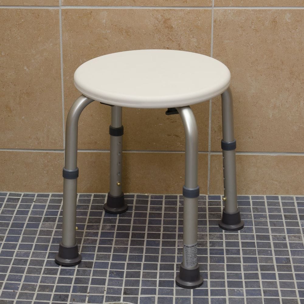 Round shower stool with metal legs on a tiled bathroom floor.