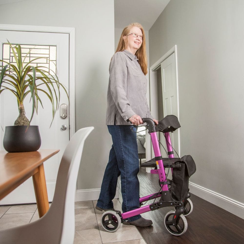 Person using a pink and black scooter in a home setting