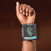 Hand wearing a healthsmart blood pressure monitor on a brown background