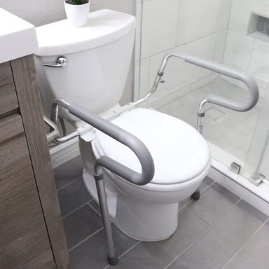Bathroom setup with a toilet and grab bars for safety