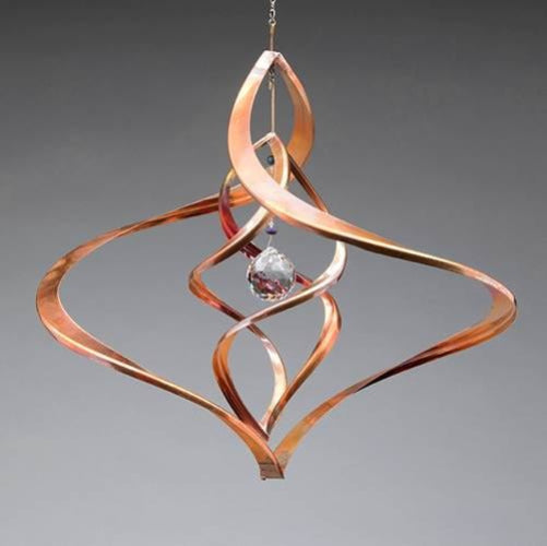 Copper wind chime with crystal on a gray background