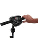 Hand operating a scooter handlebar with control buttons on a white background