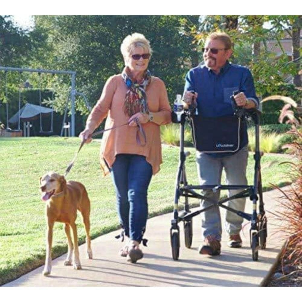 Man using a walker and woman walking a dog on a path in a park