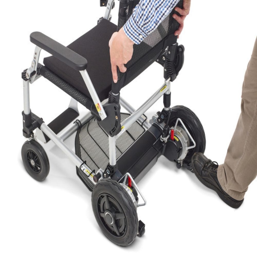 Person using a manual folding wheelchair on a white background