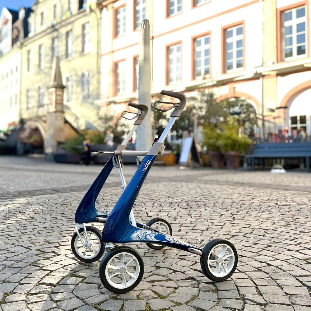 Blue and silver golf trolley on a cobblestone street with buildings in the background