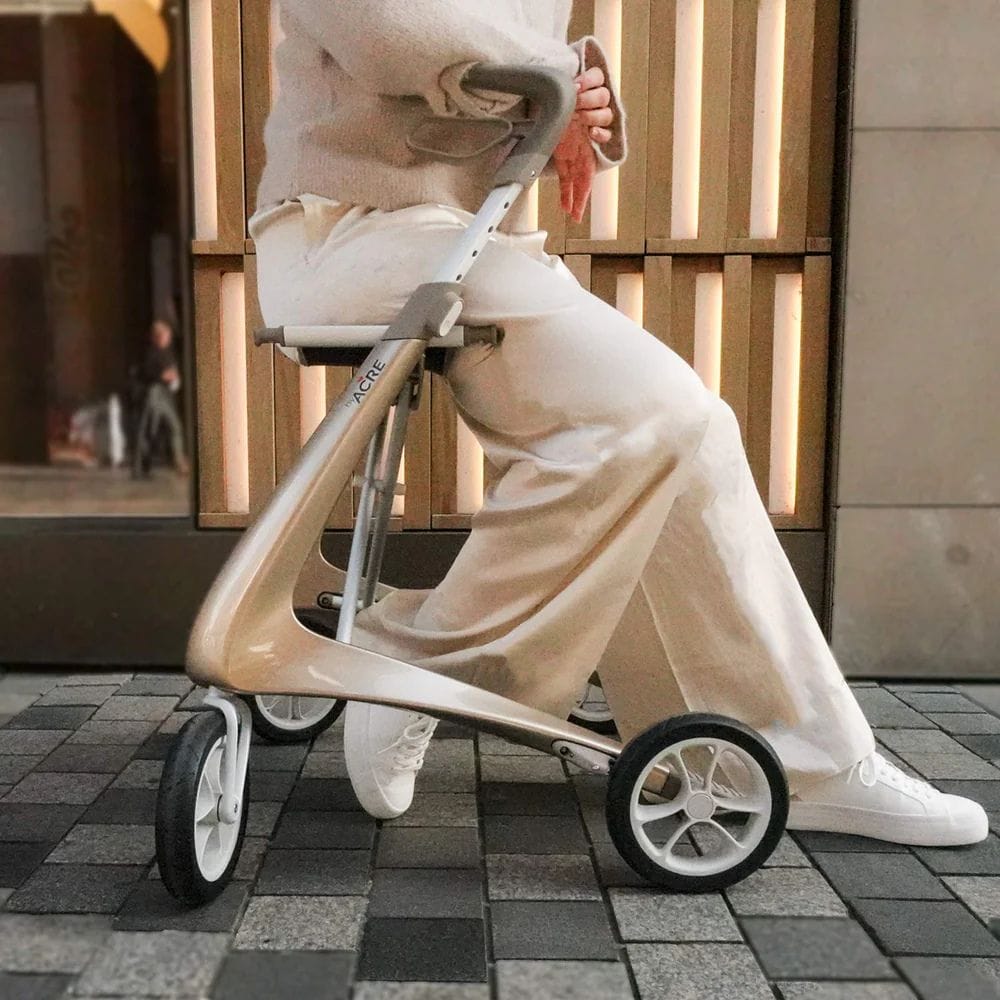 Person using a modern stroller on a tiled pavement.