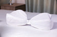 Two white Legacy Pillow Cases joined together on a bed to connect two leg pillows for full-leg support.