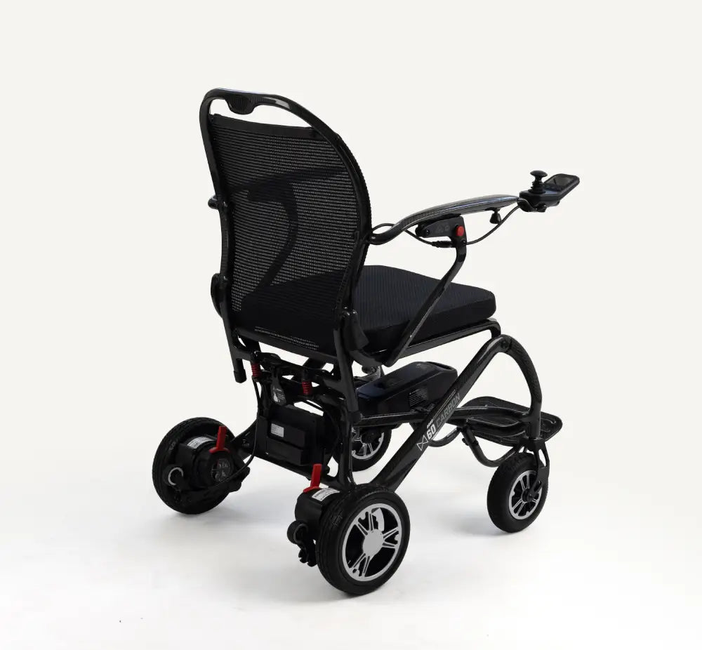 A black electric wheelchair with a mesh backrest, padded seat, and small front caster wheels, photographed on a clean white studio background.