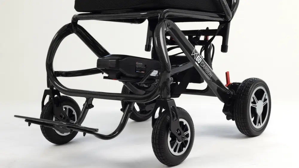 A black electric wheelchair with a sleek frame, three wheels, and a footrest, photographed on a clean white studio background.