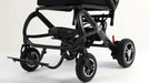 A black electric wheelchair with a sleek frame, three wheels, and a footrest, photographed on a clean white studio background.