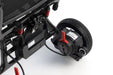 Close-up of a black electric scooter or quad bike rear suspension and wheel assembly, featuring a black tire, black motor, red handlebar lever, and red shock absorbers on a white background.