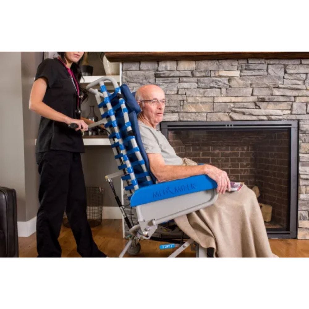 Person using a blue and gray lift chair with another person assisting them in a home setting.