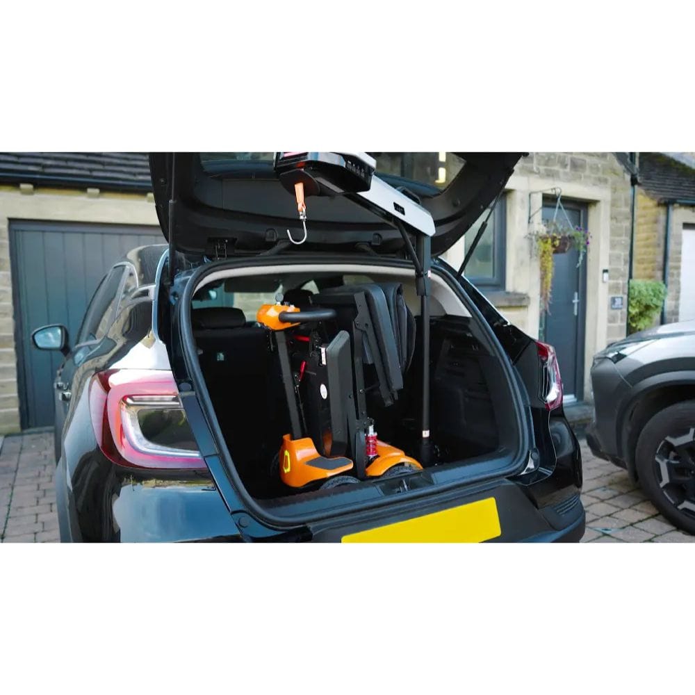 Car trunk with a bike rack and two bicycles inside, parked on a driveway.