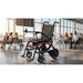 Foldable wheelchair in an airport terminal with people sitting in the background
