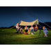 Family camping under a starry sky with a tent and string lights.