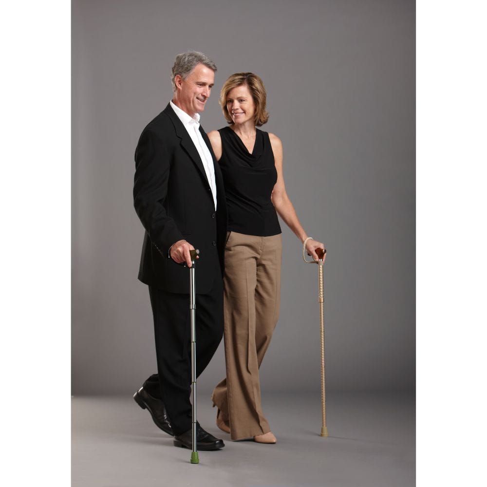 Man and woman standing side by side holding canes against a gray background